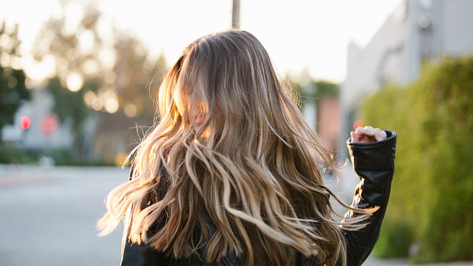 Vrouw met donkerblond haar na gebruik shampoo Garnier