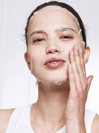 Model met Nutribomb Amandel Sheet Mask op gezicht